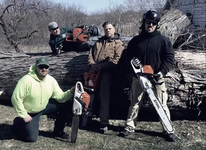 Urban Loggers LLC professional tree service crew with chainsaws and felled logs in Milwaukee WI